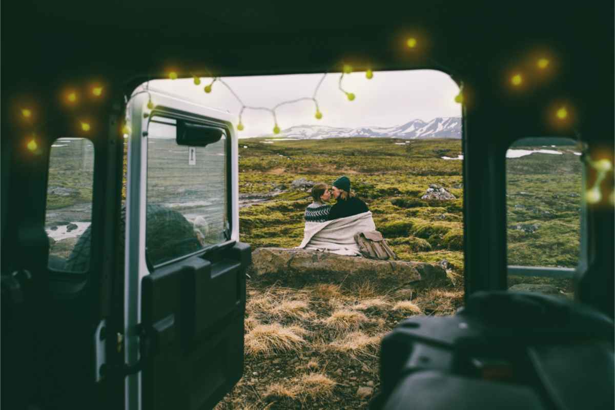 Pareja disfrutando del paisaje de las Tierras Altas de Islandia junto a su camper