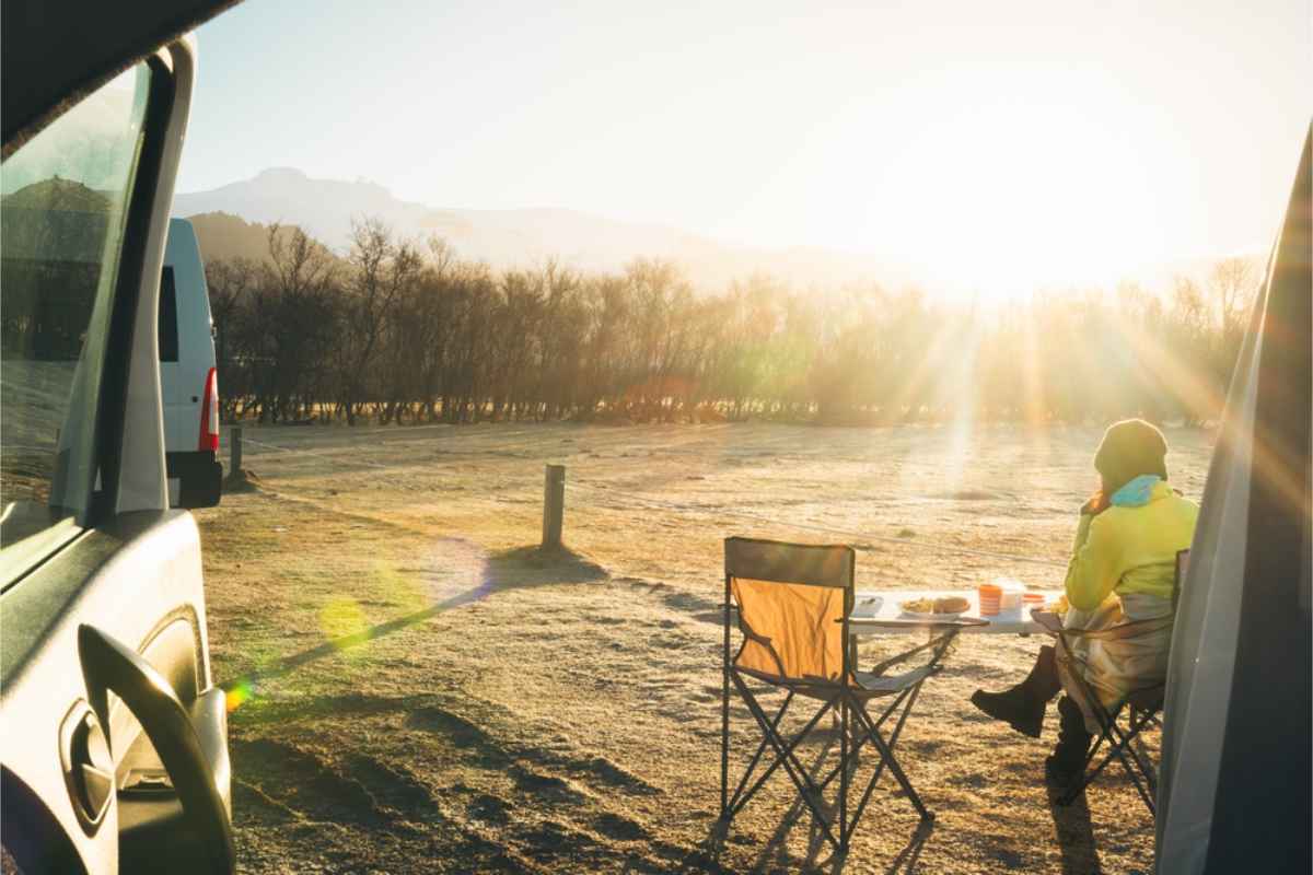 Touriste marchant juste à côté de son camping-car blanc par une journée ensoleillée