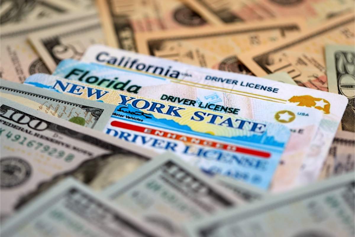 Des permis de conduire américains empilés sur plusieurs billets de dollar