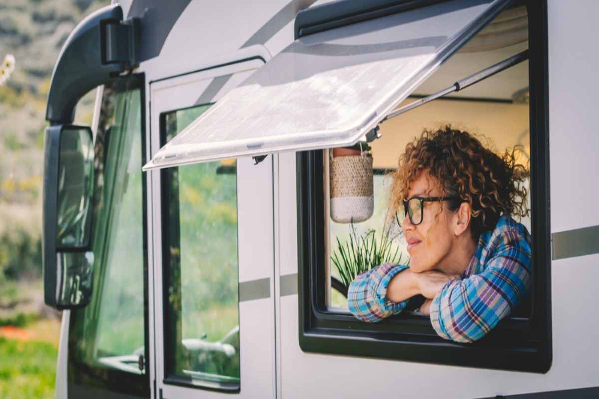 Silhouette of a person watching a solar eclipse with the sun’s corona glowing behind them.