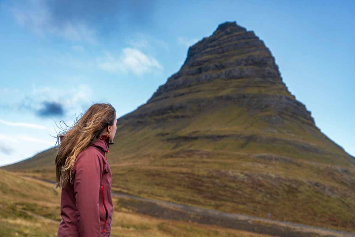 Traveler looking up at Kirkjufell mountain in Iceland