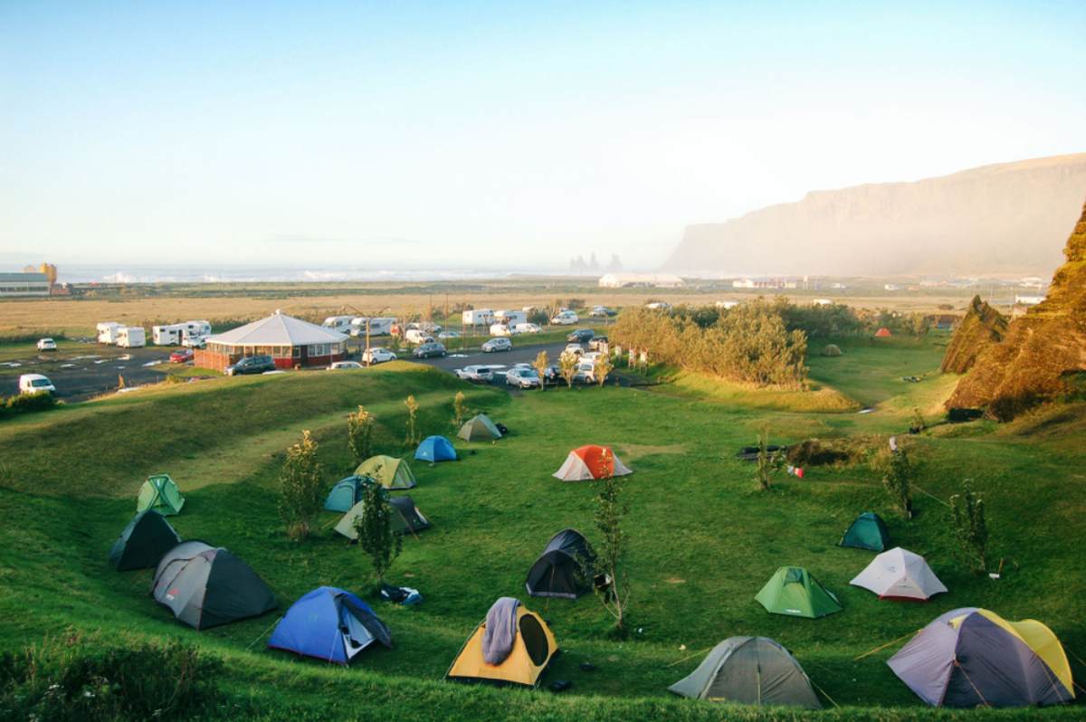 Zwei Personen neben ihrem Camper und genießen die Aussicht vom Campingplatz