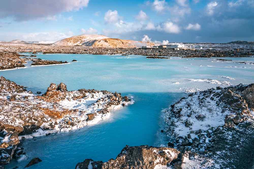 Iceland's Blue Lagoon Turquoise geothermal waters of the Blue Lagoon surrounded by snow-covered lava fields under a dramatic winter sky in Iceland.