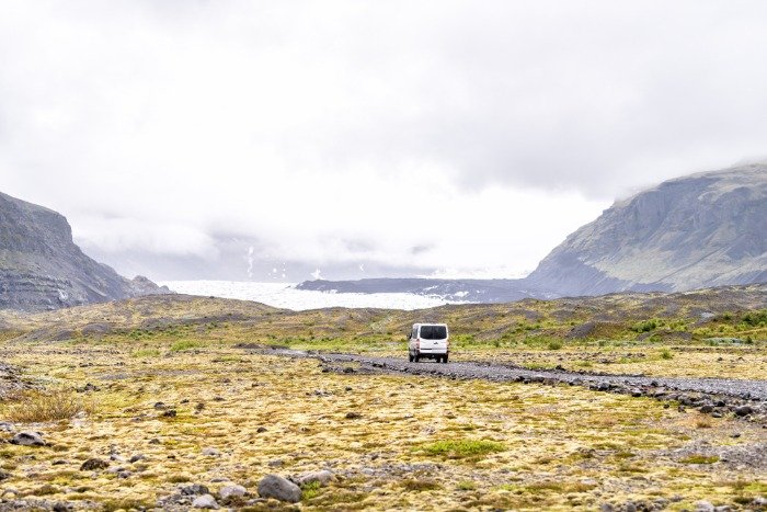 A stunning view on Skaftafell National Park in Iceland with a campervan going down the gravel road
