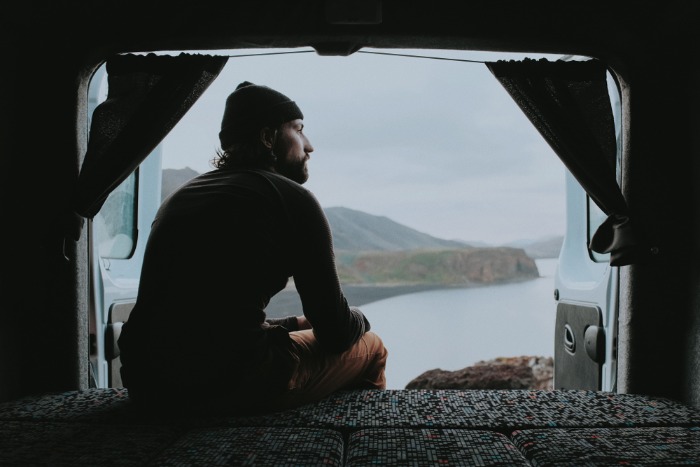 Male tourist sittiong in rented campervan with the view on Icelandic landscape