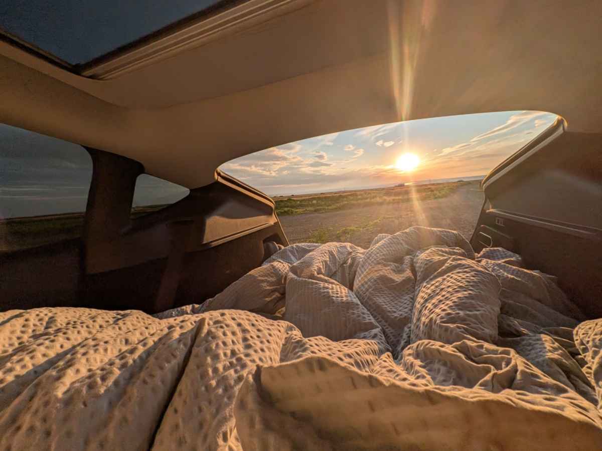 Innenraum eines Wohnmobils mit gemütlicher Decke und Sonne durch die Hecktür