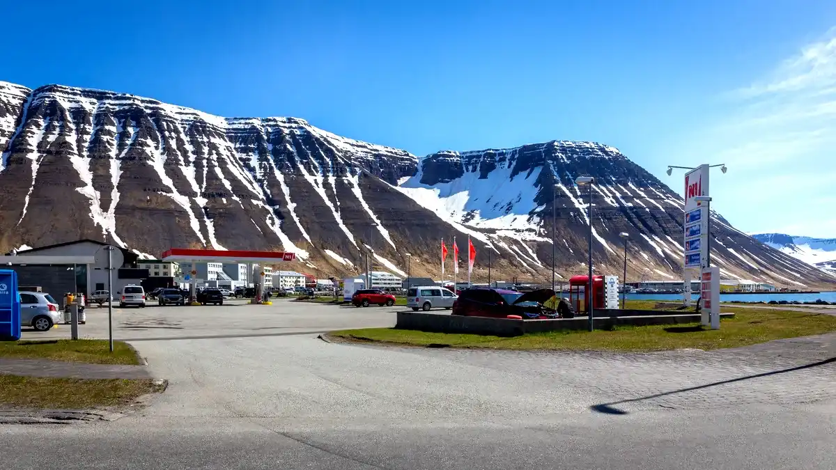 N1-Tankstelle in Island mit schneebedeckten Bergen und einem Fjord im Hintergrund.