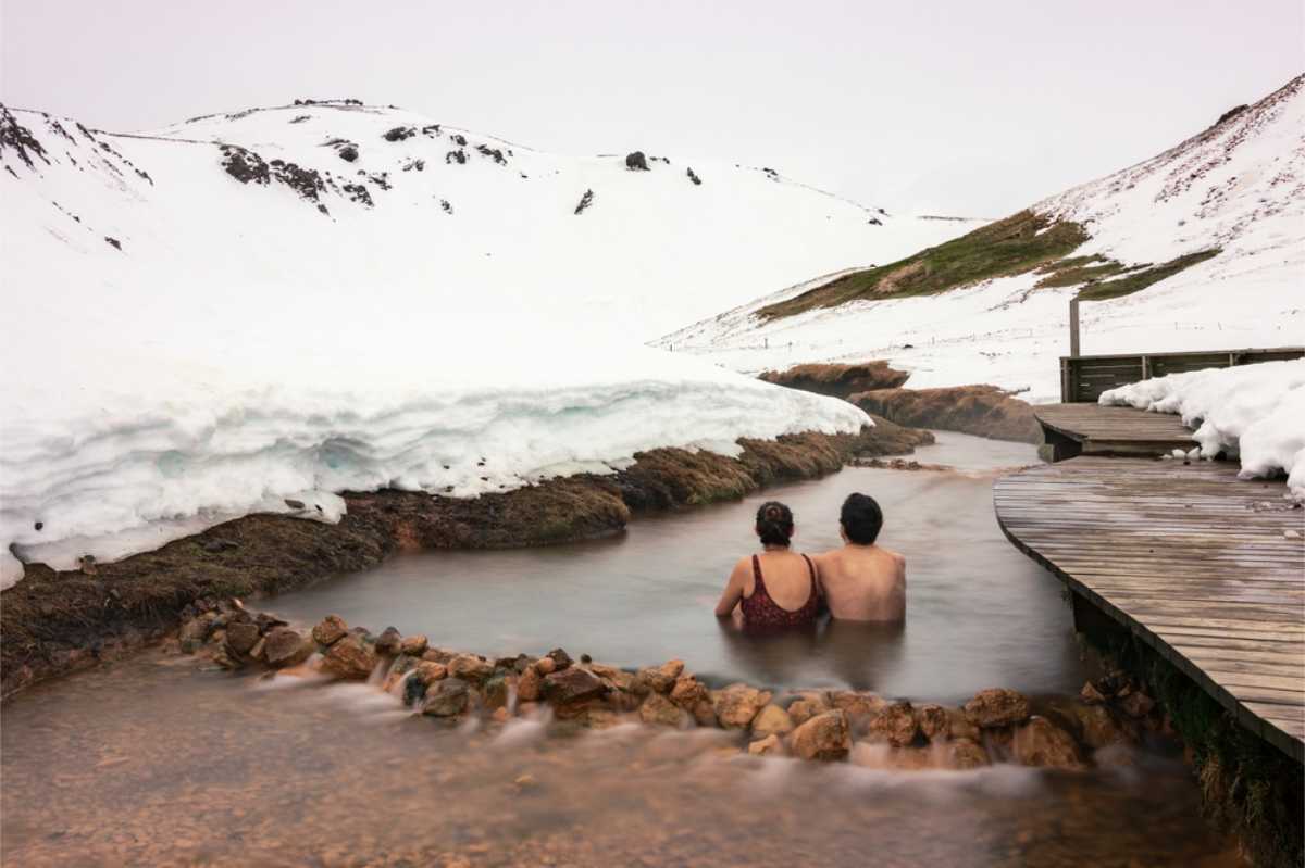 Ein Paar genie&szlig;t im Winter das warme Wasser in Reykjadalur