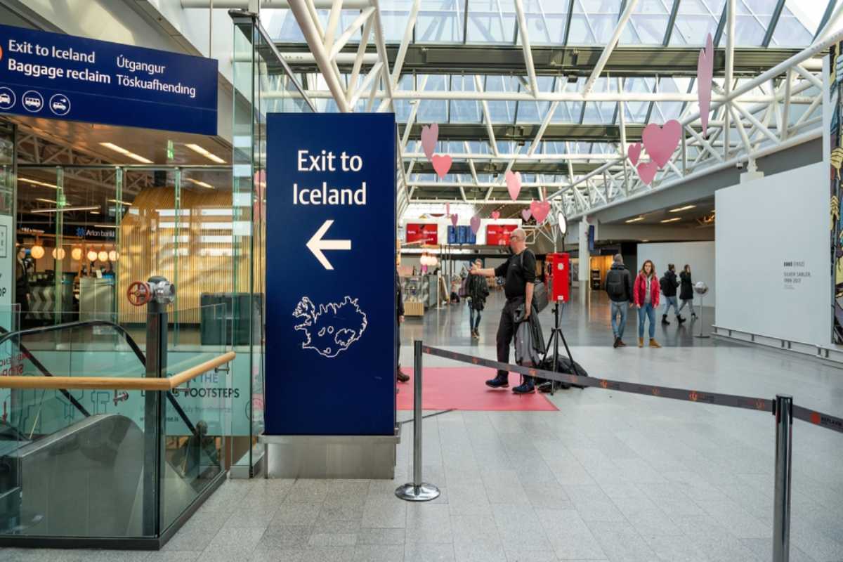 Aeropuerto de Keflavík Interior del aeropuerto de Keflavík con un gran cartel que señala a los viajeros la salida hacia Islandia