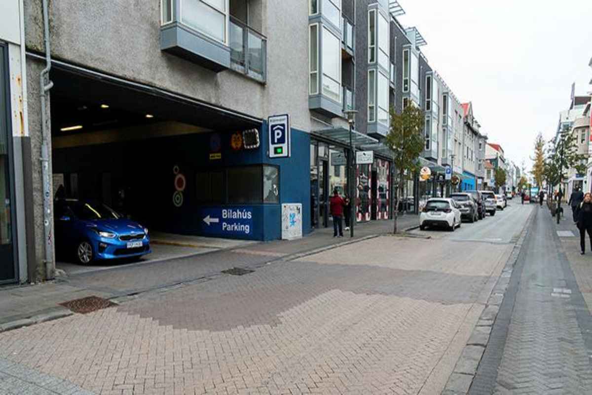 Coche entrando en el garaje Stj&ouml;rnuport en una calle c&eacute;ntrica de Reikiavik rodeada de tiendas y apartamentos