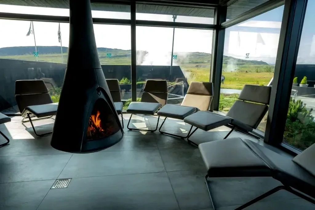 Rejuvenécete en el baño de vapor de Krauma Spa – La mejor experiencia de bienestar en Islandia Instalación de baño de vapor en Krauma spa en Islandia, con arquitectura elegante de madera negra y vapor elevándose en la luz de la mañana.