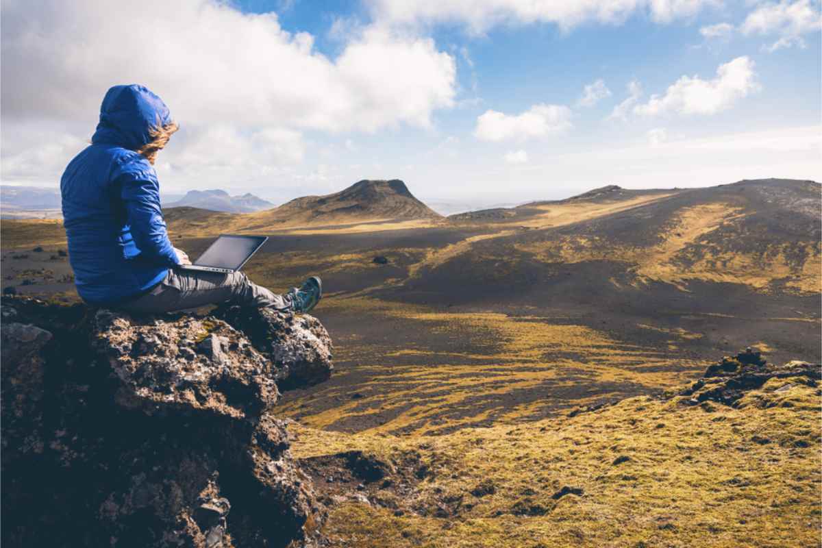 Turista usando su portátil en una zona remota de Islandia