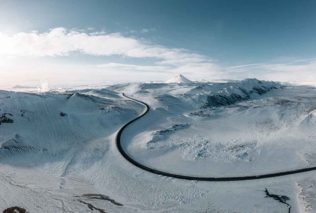 Route sinueuse au milieu d’un paysage enneigé