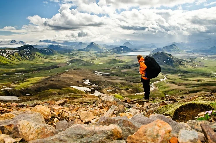 Randonneur solitaire avec un grand sac à dos, debout sur une pente rocheuse en Islande. Randonneur solitaire avec un grand sac à dos, debout sur une pente rocheuse en Islande.
