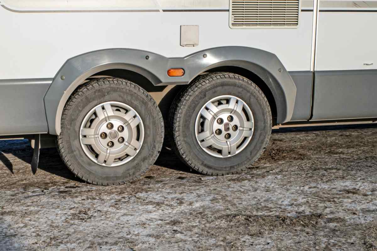 Pneus hiver pour camping-car Gros plan sur des roues arrière jumelées de camping-car prêtes pour des routes d’hiver verglacées.