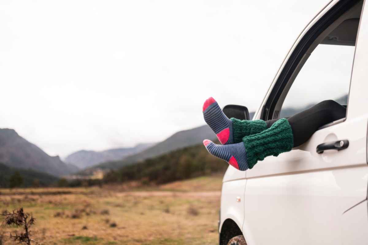 Chaussettes en laine confortables d&eacute;passant de la fen&ecirc;tre d&rsquo;un camping-car blanc lors d&rsquo;un road trip froid en Islande.