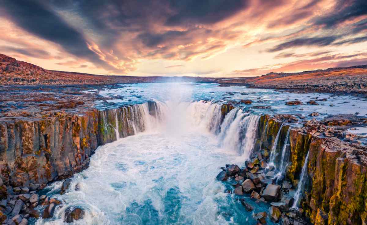 Puissante chute d'eau de Selfoss cascade sur des falaises de basalte escarpées dans un paysage volcanique spectaculaire, avec de la brume s'élevant de