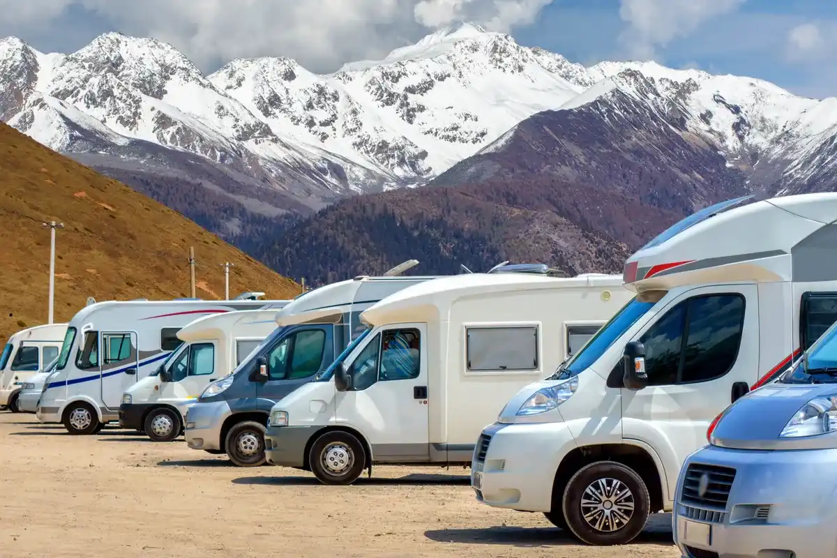Fila di camper e motorhome parcheggiati in un&rsquo;area designata