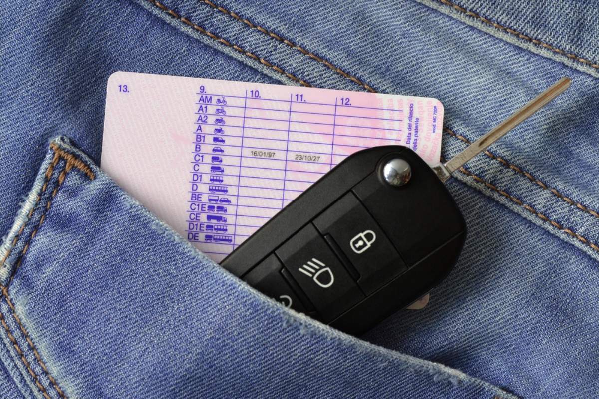 Chiave dell&rsquo;auto e patente di guida nella tasca di un paio di jeans