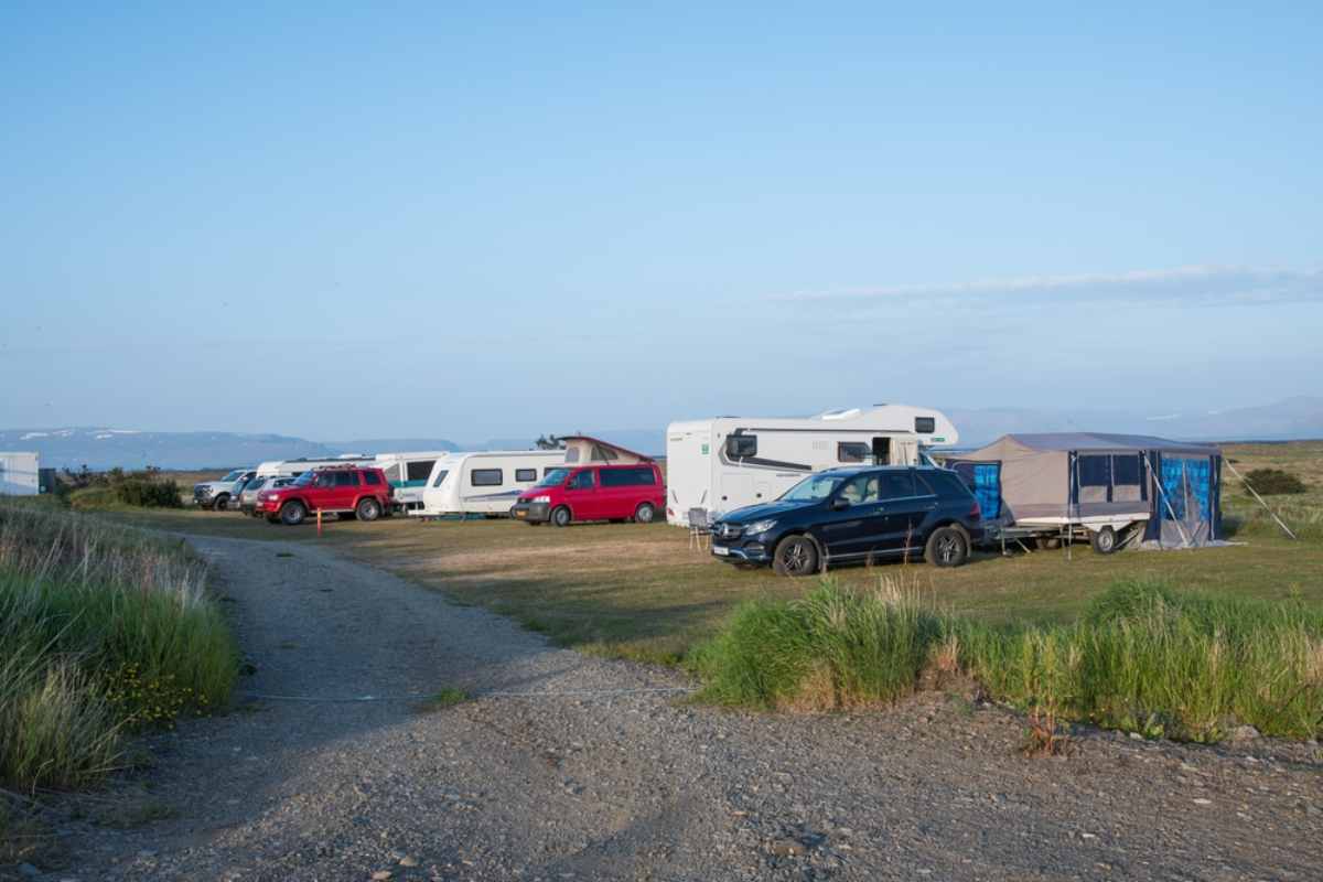 Campeggi in Islanda Campeggio in Islanda con auto parcheggiate, camper e motorhome sotto un cielo sereno