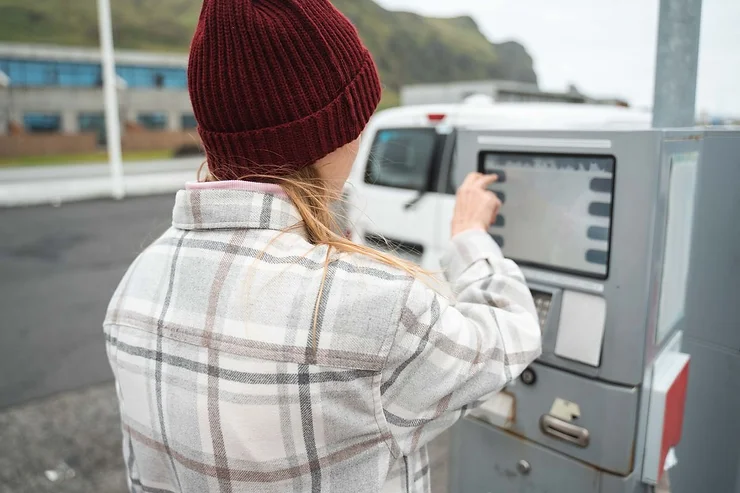 Macchina di pagamento self-service in Islanda Viaggiatrice che usa una macchina di pagamento self-service in una stazione di servizio islandese.