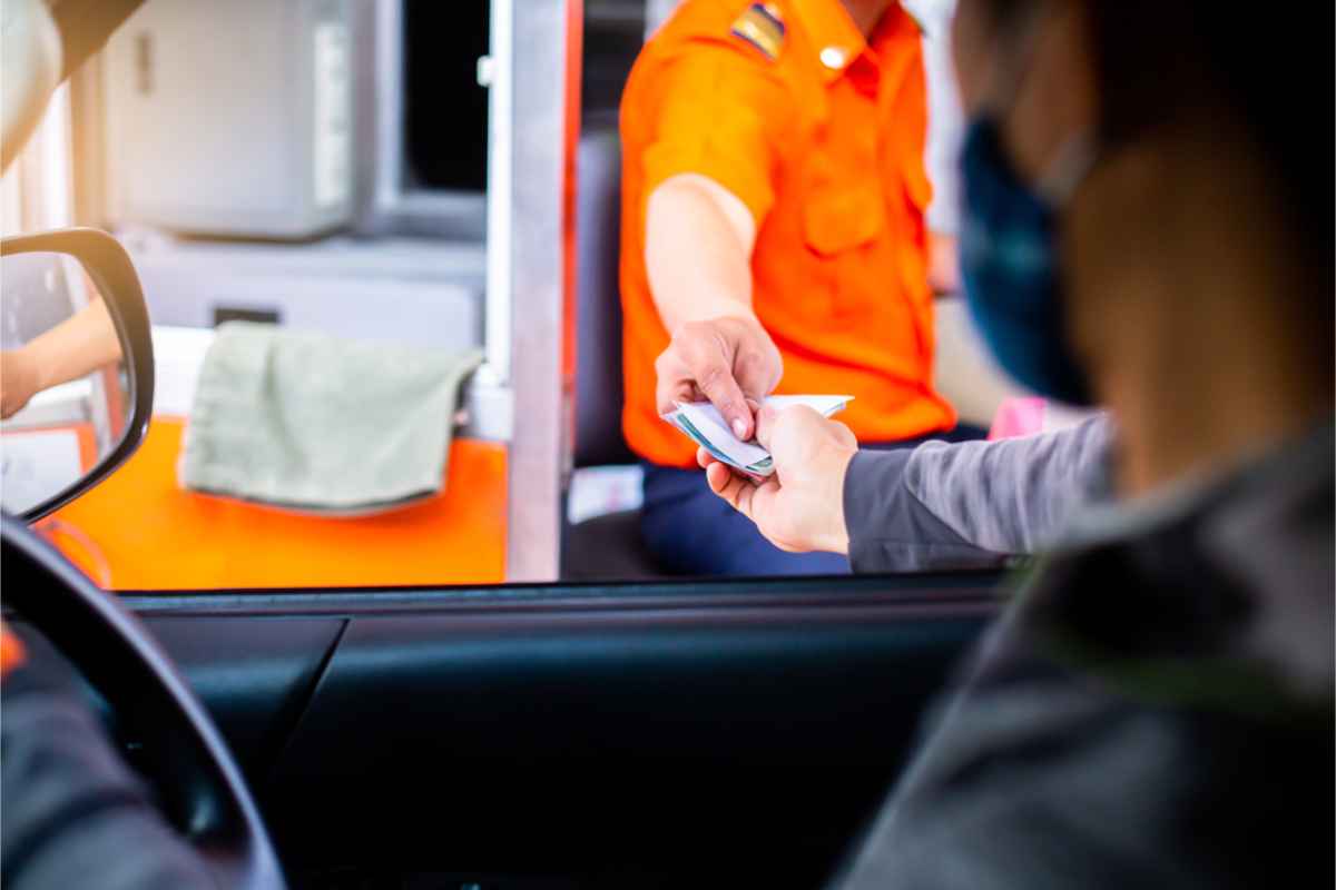 Uomo che paga il pedaggio al casello